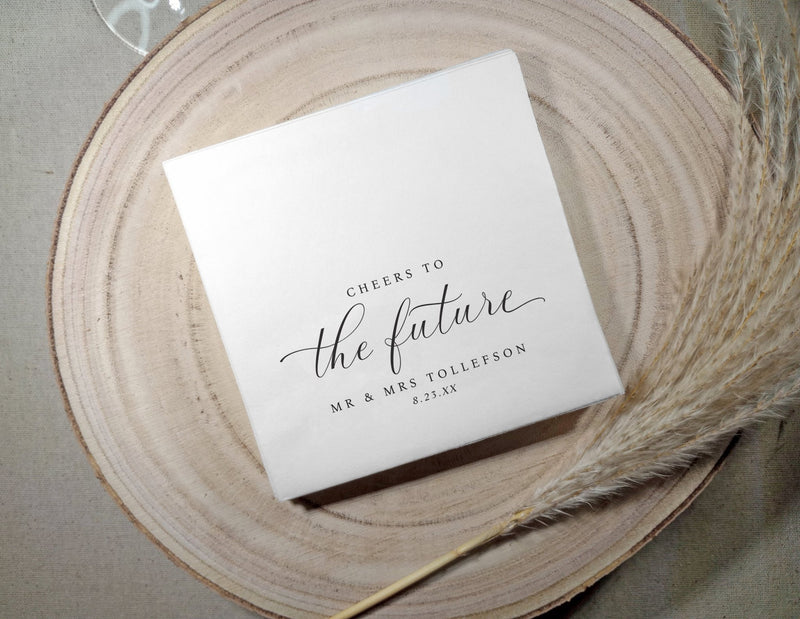 Personalized cocktail napkins with “cheers to the future.” Elegant for engagement parties, rehearsal dinners, or bridal showers.