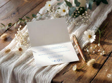 Folded thank you card with a pen on a wooden surface with flowers