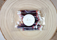 his and her personalized wedding favor stickers applied to wrapped candy favors