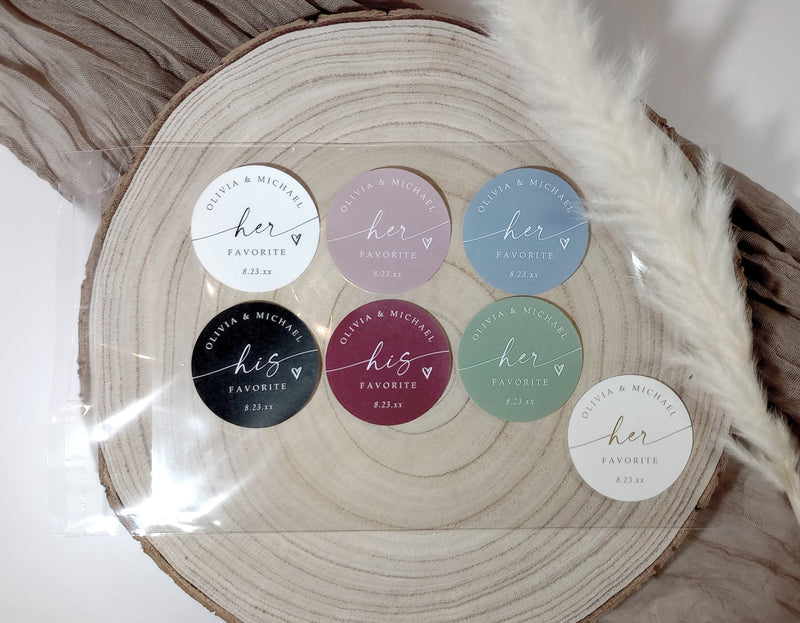 assorted his and her wedding favor stickers in various colors displayed on wood round