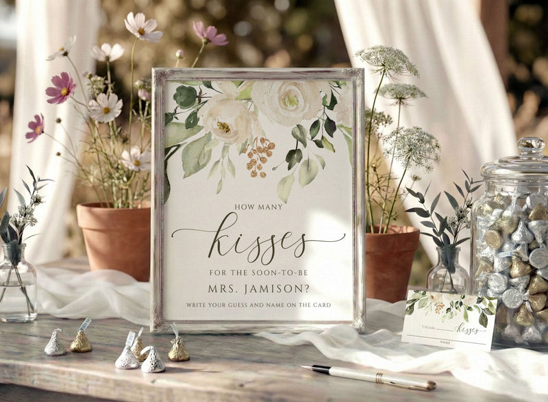 Decorative bridal shower table setting with a floral sign asking 'How many kisses for the soon-to-be Mrs. Jamison?'