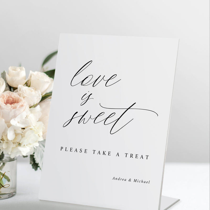 Standing “Love is Sweet” wedding sign in modern romantic calligraphy displayed on a wedding dessert bar table.