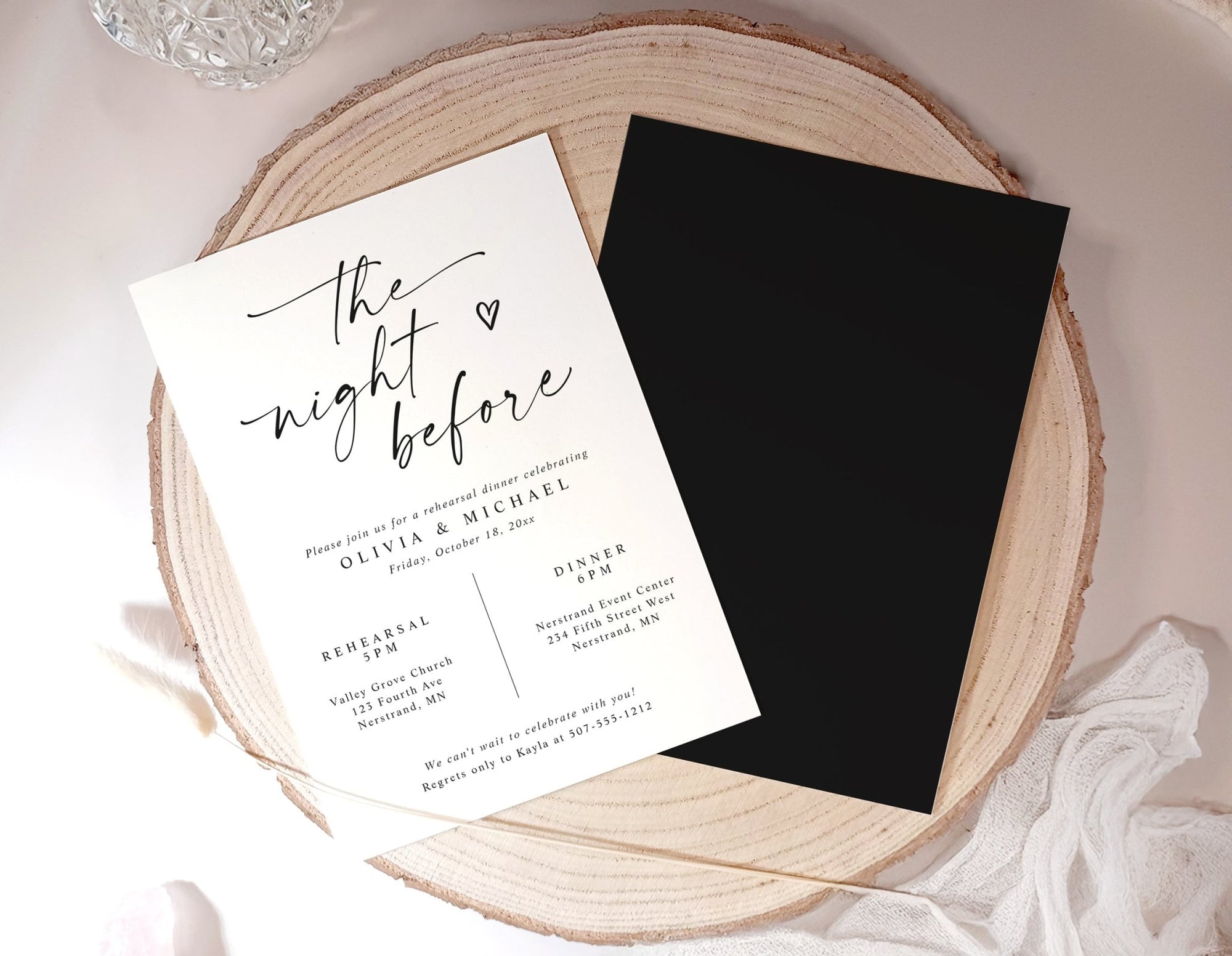 Wedding rehearsal dinner invitation card on a wooden surface with a black card beside it.