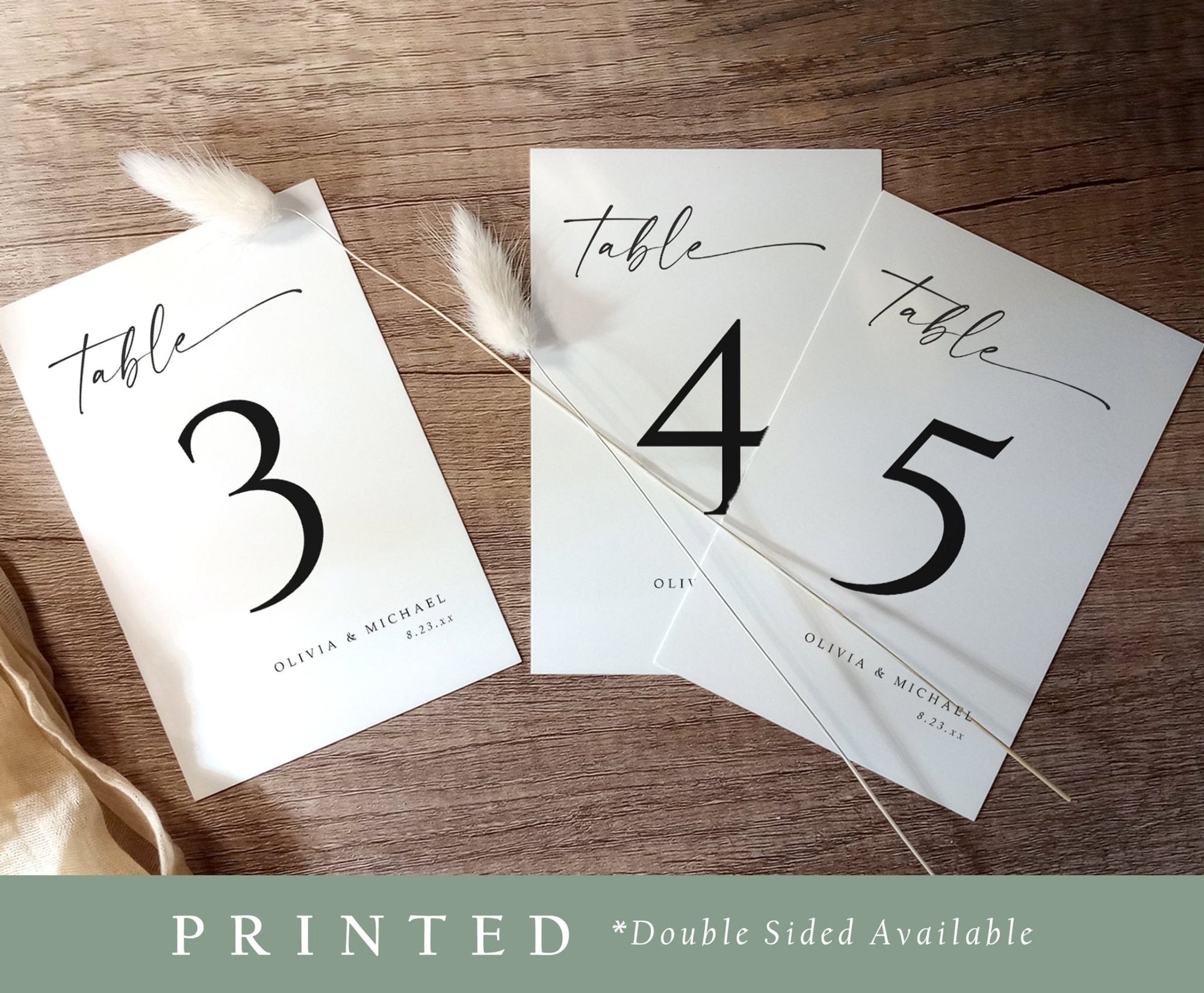 Printed wedding table numbers 3, 4, and 5 in clean black font with script accents on wood surface