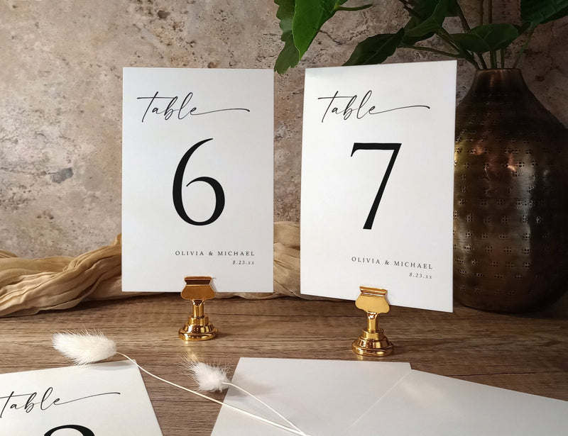 Custom printed table number cards for wedding in minimalist black and white design with handwritten script