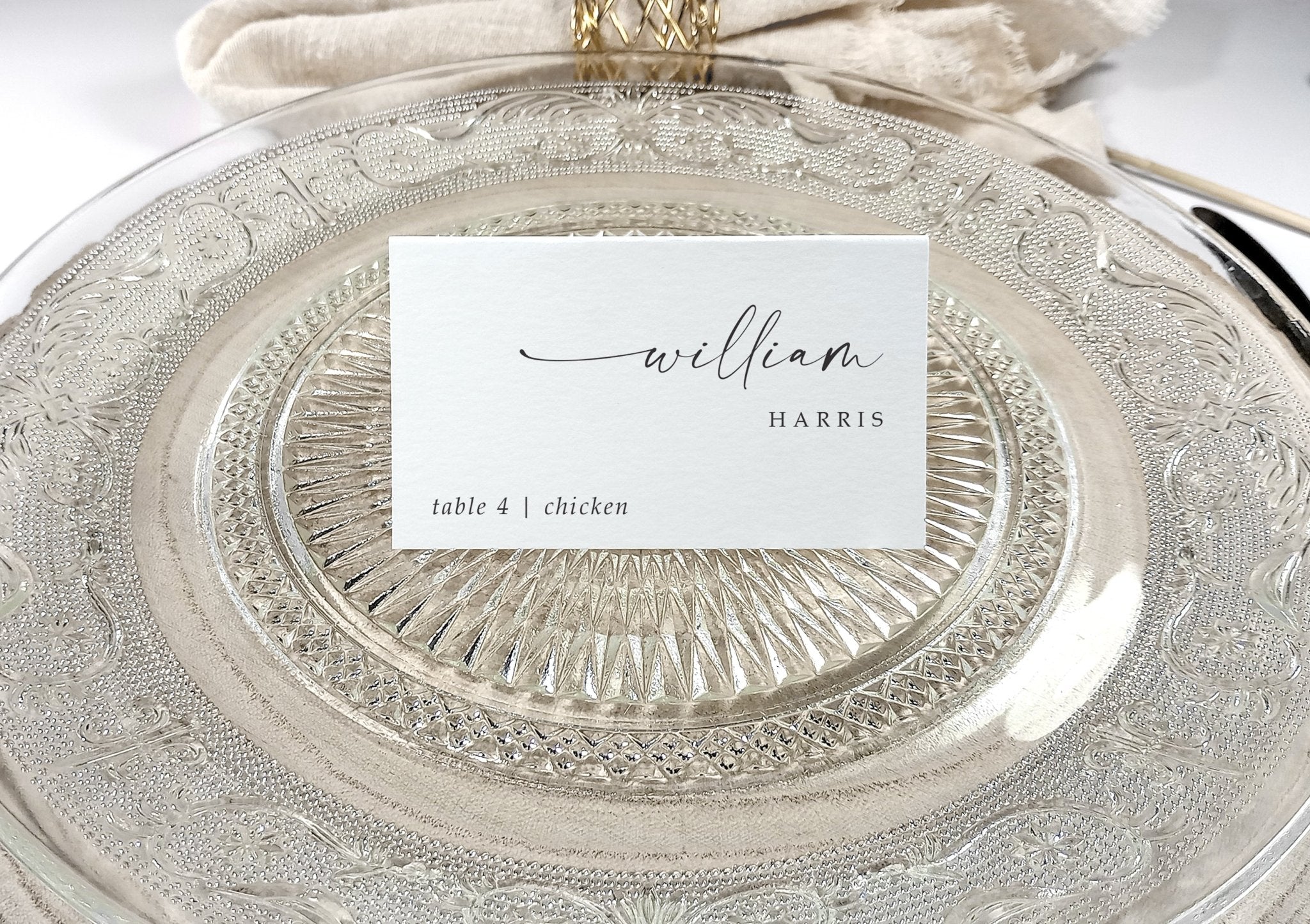 Elegant wedding place card on wood charger plate with clean black calligraphy font