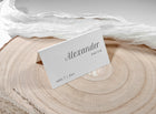 Tented name card with clean black text, styled on wood with sheer fabric