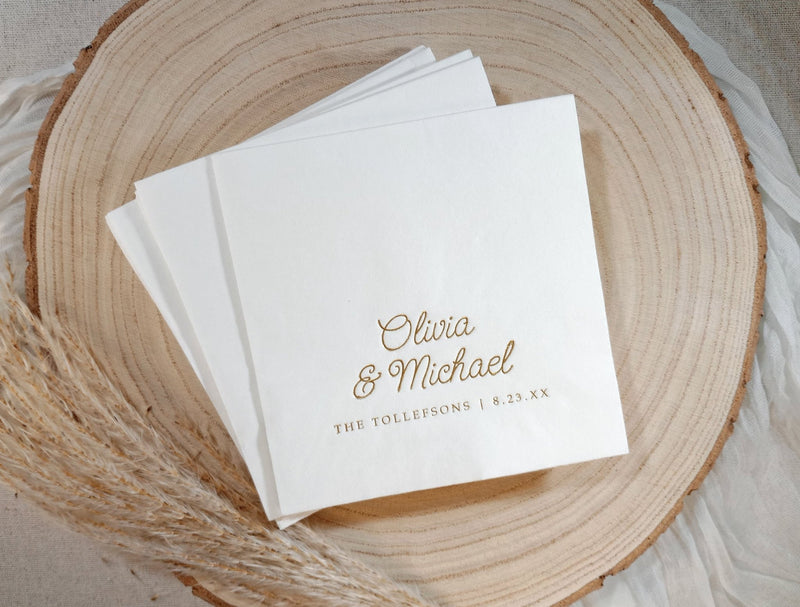 Personalized wedding napkin with whimsical script names in gold foil on wood plate