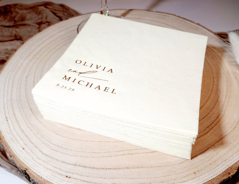 White napkin with 'Olivia & Michael' text on a wooden surface