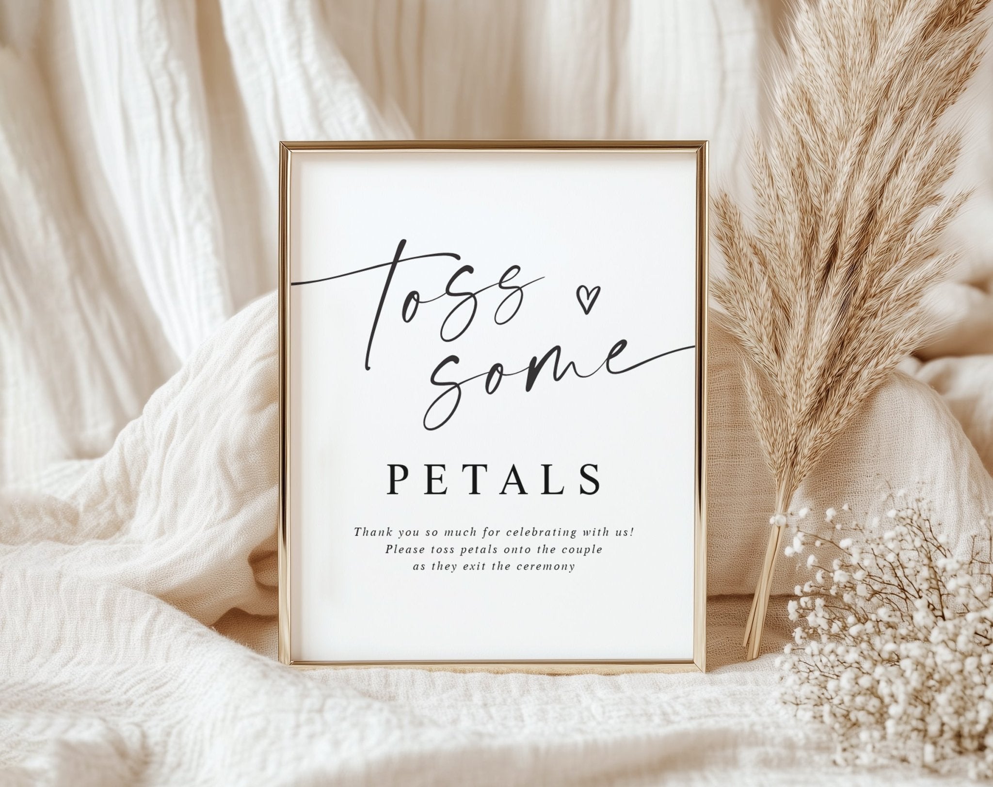 White Toss Some Petals sign with elegant calligraphy and serif font, displayed in a neutral boho wedding setup