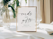 Framed printed wedding sign on a table with 'cards and gifts' text, surrounded by decorative elements.