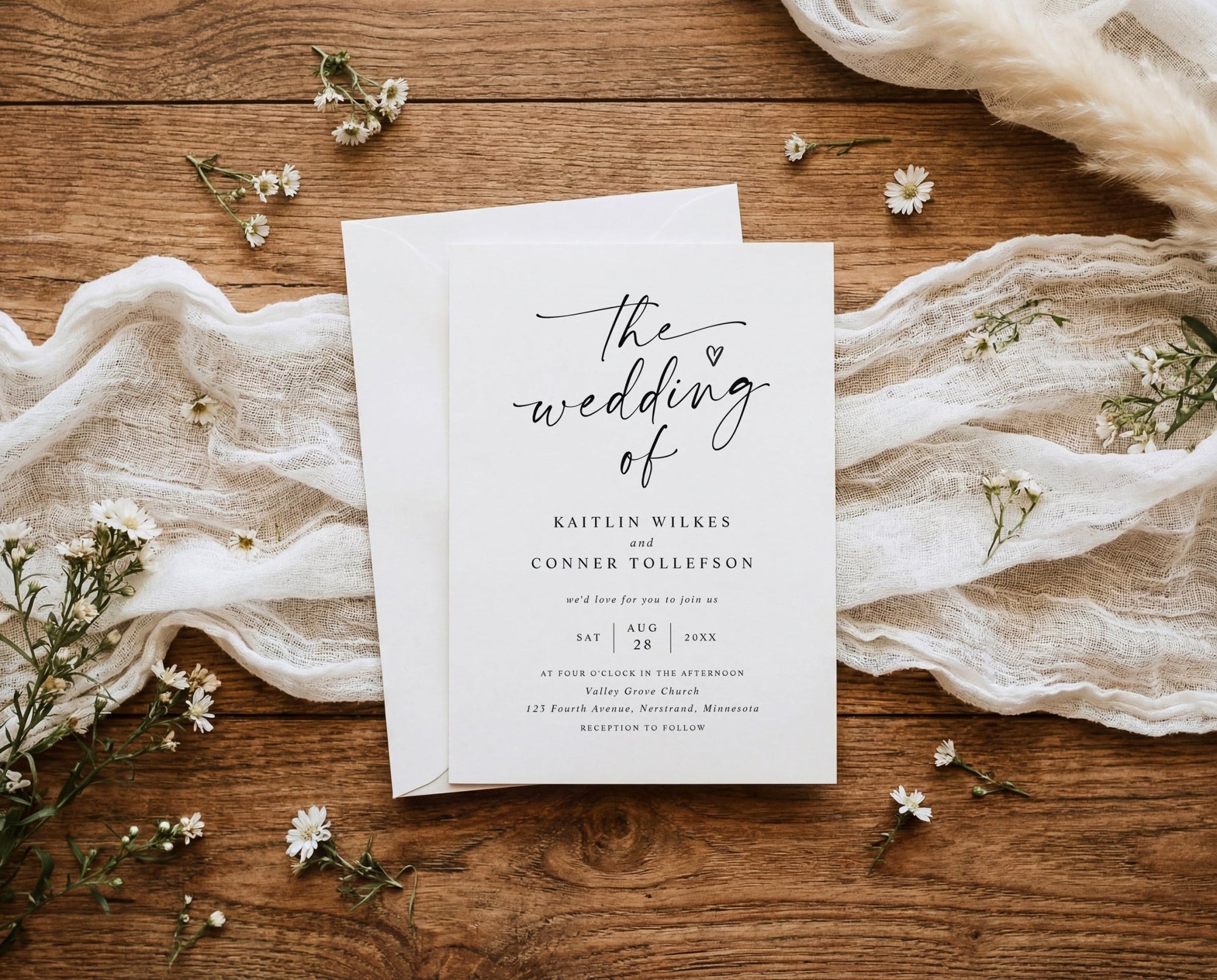 Wedding invitation card on a wooden surface with floral decorations