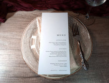 Custom wedding menu cards printed with bottom-aligned layout, stacked on plates for reception table décor.