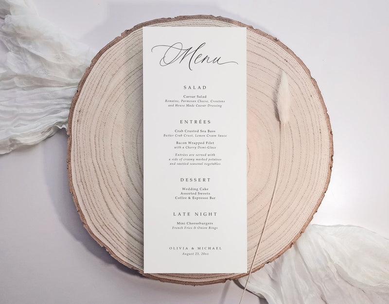 Custom printed modern wedding menu card on white cardstock with black serif font, styled on linen napkin.