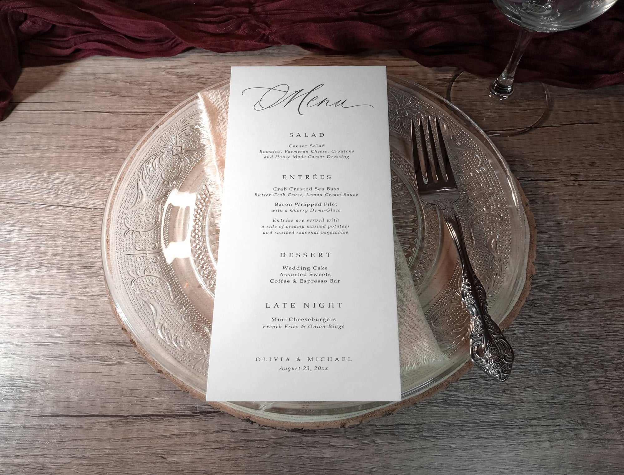 Elegant wedding menu card on a glass plate with silverware on a wooden table