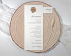 Menu card with attached name tag on a wooden slice with a white background