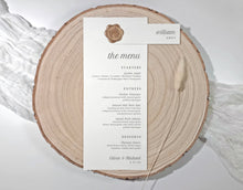 Menu card with attached name tag on a wooden slice with a white background