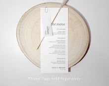 Wedding menu card with translucent name tag n a wooden round board with 'the menu' text.