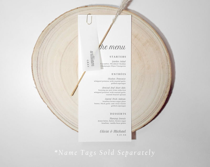 Wedding menu card with translucent name tag n a wooden round board with 'the menu' text.