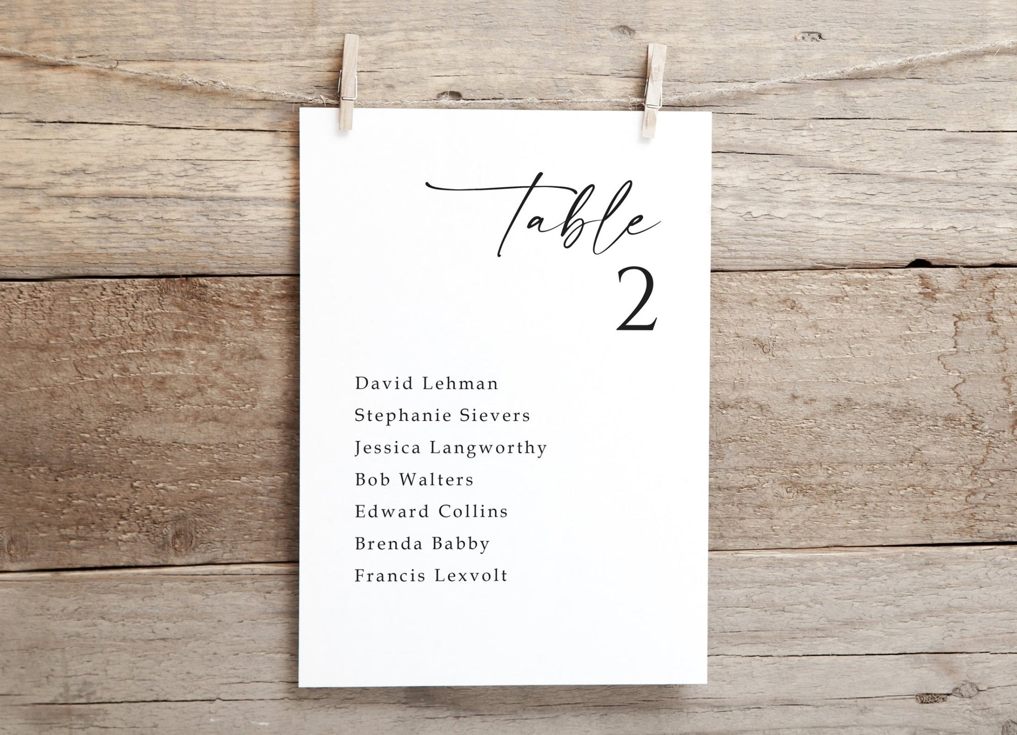 Single wedding seating chart card for Table 2, printed in elegant handwriting on rustic wood background.