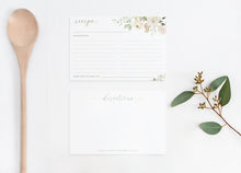 Recipe card with floral design, wooden spoon, and eucalyptus leaves on a white background