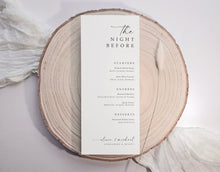 Menu card titled 'The Night Before' on a wooden surface with a soft background