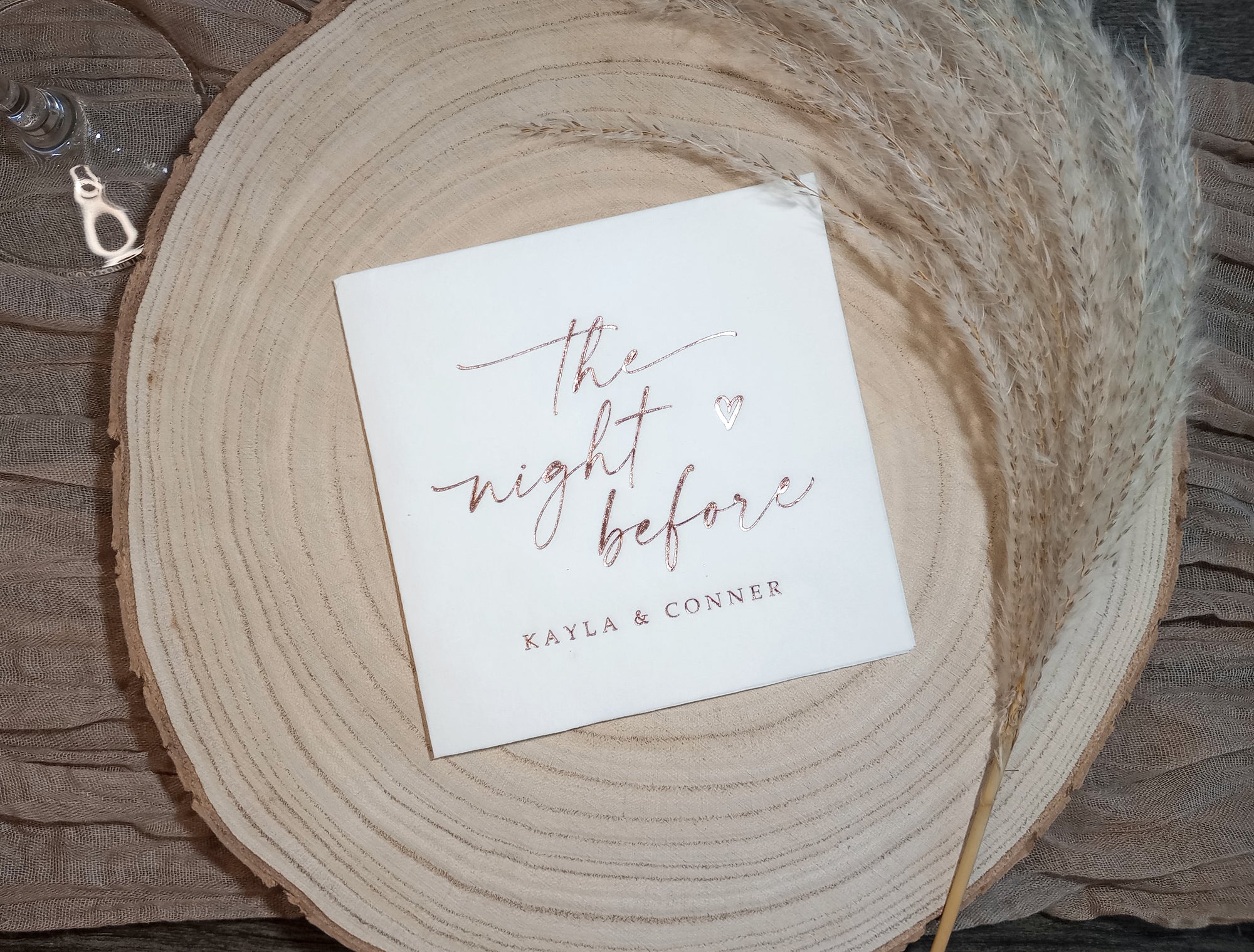 Close-up of personalized foil-stamped wedding napkin for a rehearsal dinner, shown in gold foil.