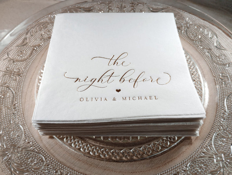 Stack of napkins with 'the night before' and names printed on a decorative plate.