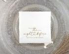 White cocktail napkin with “the night before” in black script and a hand-drawn heart, personalized with the couple’s names.