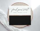 Wedding seating card with 'find your seat' text on a wooden slice and white fabric background