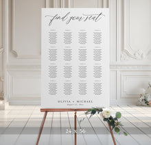 Seating chart for a wedding on an easel with decorative flowers in a elegant room.