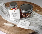 Two jars with metal lids on a wooden surface with 'Thank You' tags.