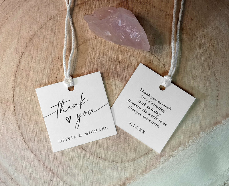 square thank you favor tags with names and date shown with string on wood and rose quartz