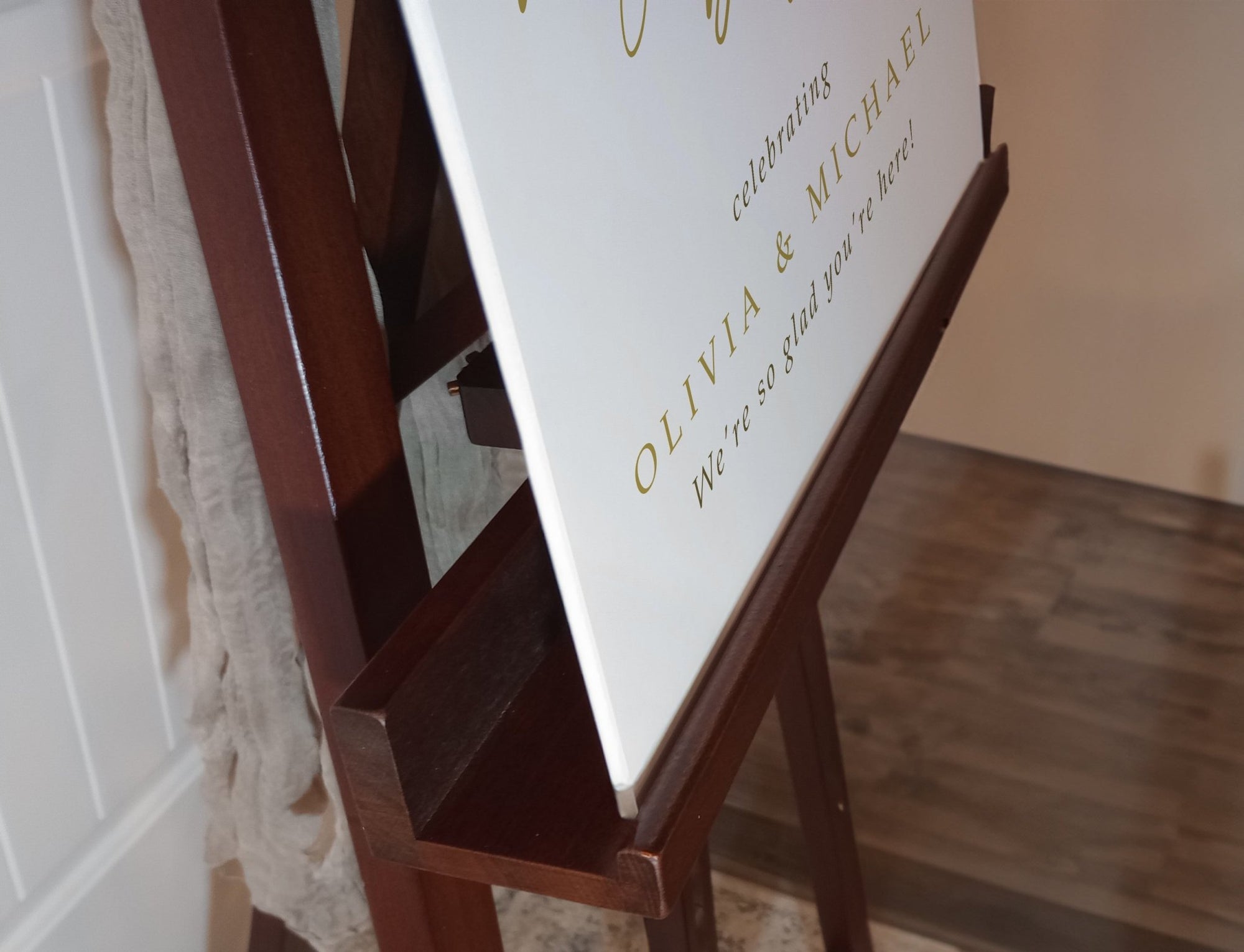 Wooden easel with a white board displaying text in a room.