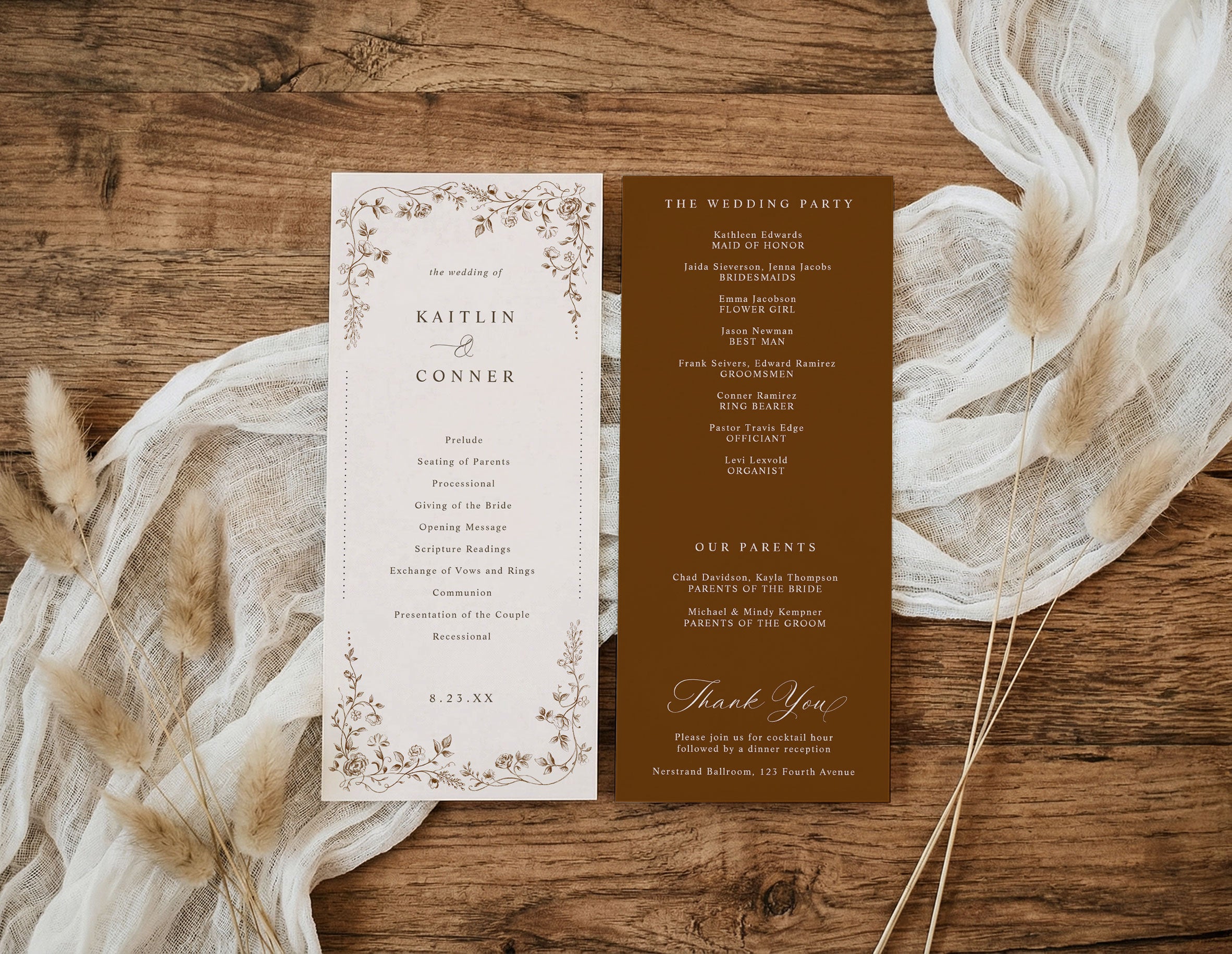 A flat-lay of a two-panel wedding program set on a rustic wooden background, styled with cream gauze fabric and dried grasses. The left panel is cream with delicate brown floral borders and black text, and the right panel is solid dark brown with matching text.