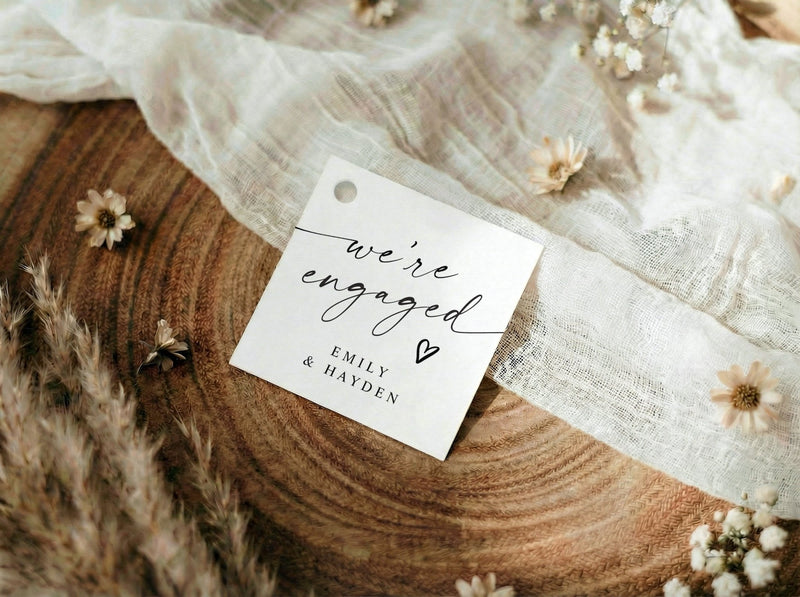 Modern black and white we're engaged favor tags with elegant handwriting and heart