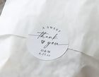 Round white label with 'A Sweet Thank You' text on a white fabric background
