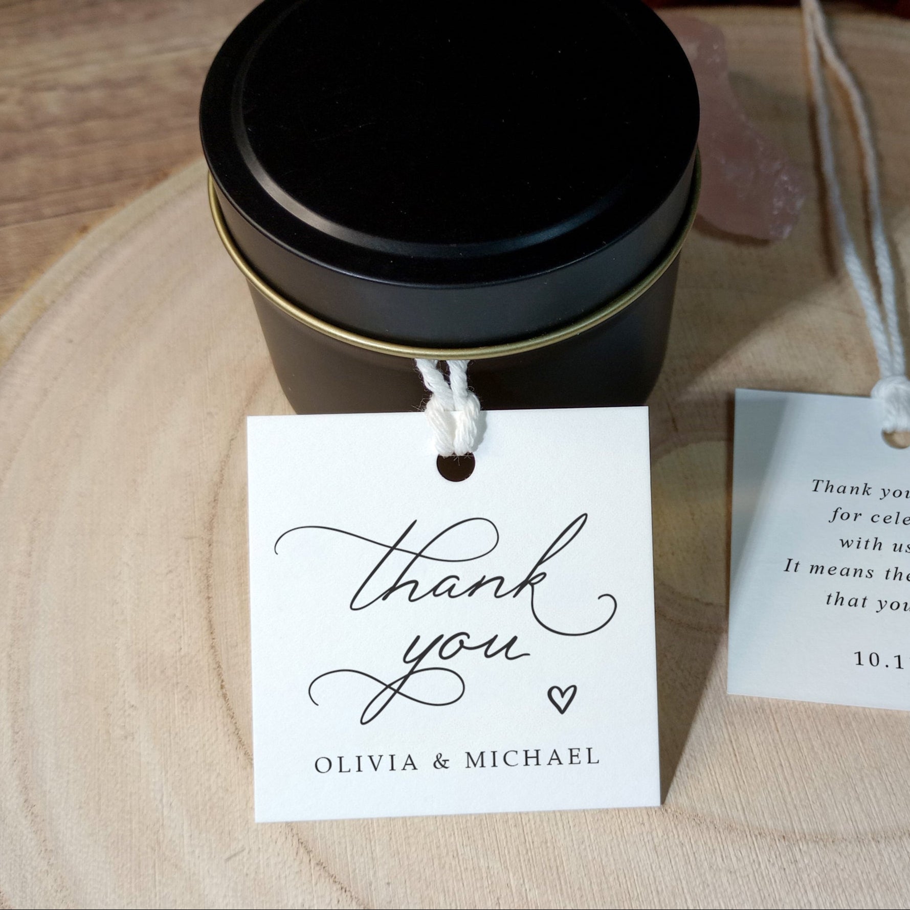 Thank-you tag tied to a small candle favor, showing front and back with personalized details.