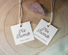 Two hanging tags on a wooden surface, one labeled 'His Favorite' and the other 'Her Favorite'.