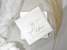 Close-up of shimmering gold foil on a white napkin featuring the couple's names, perfect for a stylish pre-wedding celebration.
