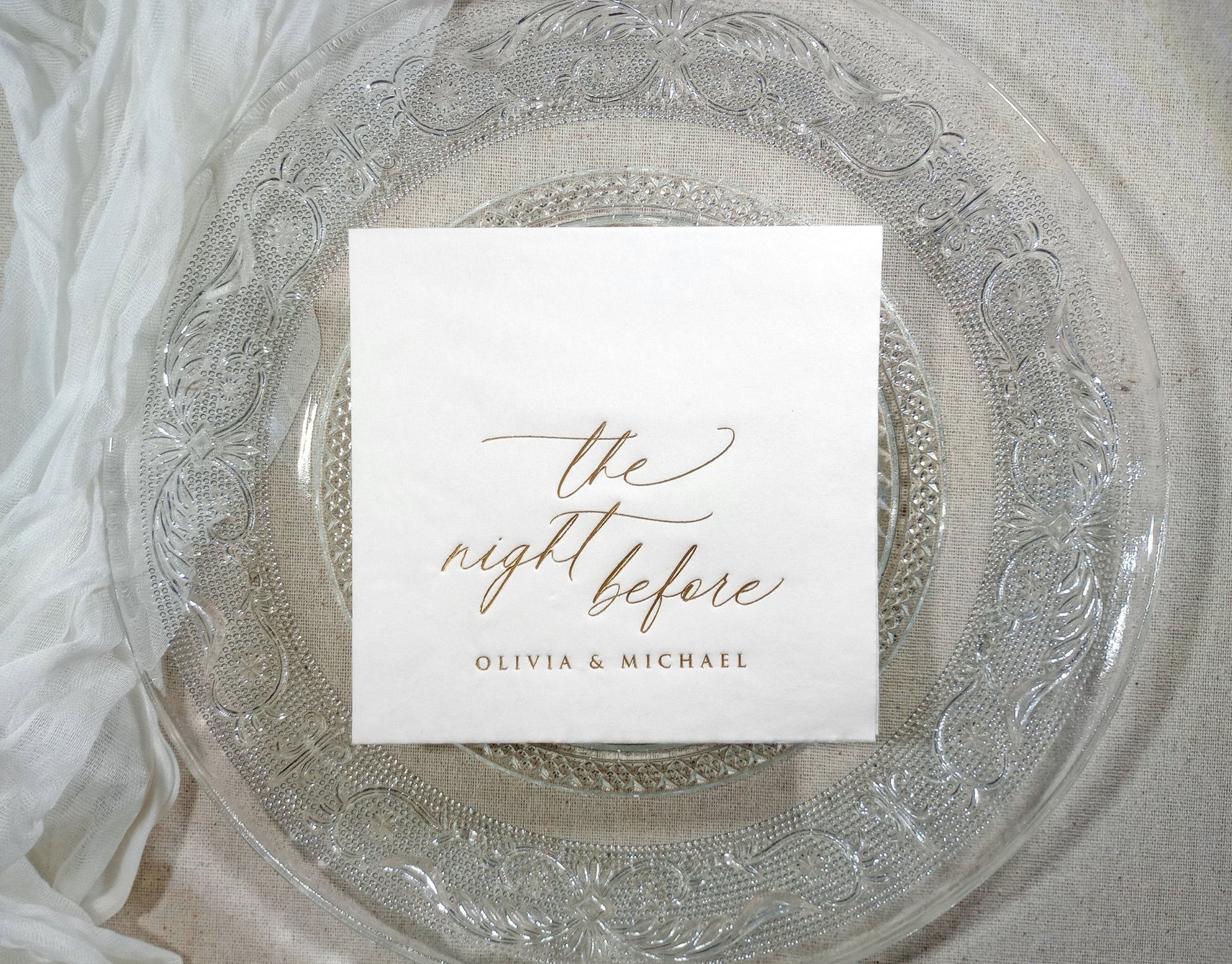 Stack of custom foil-stamped napkins in gold, silver, and rose gold, showcasing elegant rehearsal dinner designs.