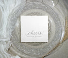 Elegant white cocktail napkin with silver foil text shown on decorative plate
