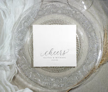 Elegant white cocktail napkin with silver foil text shown on decorative plate
