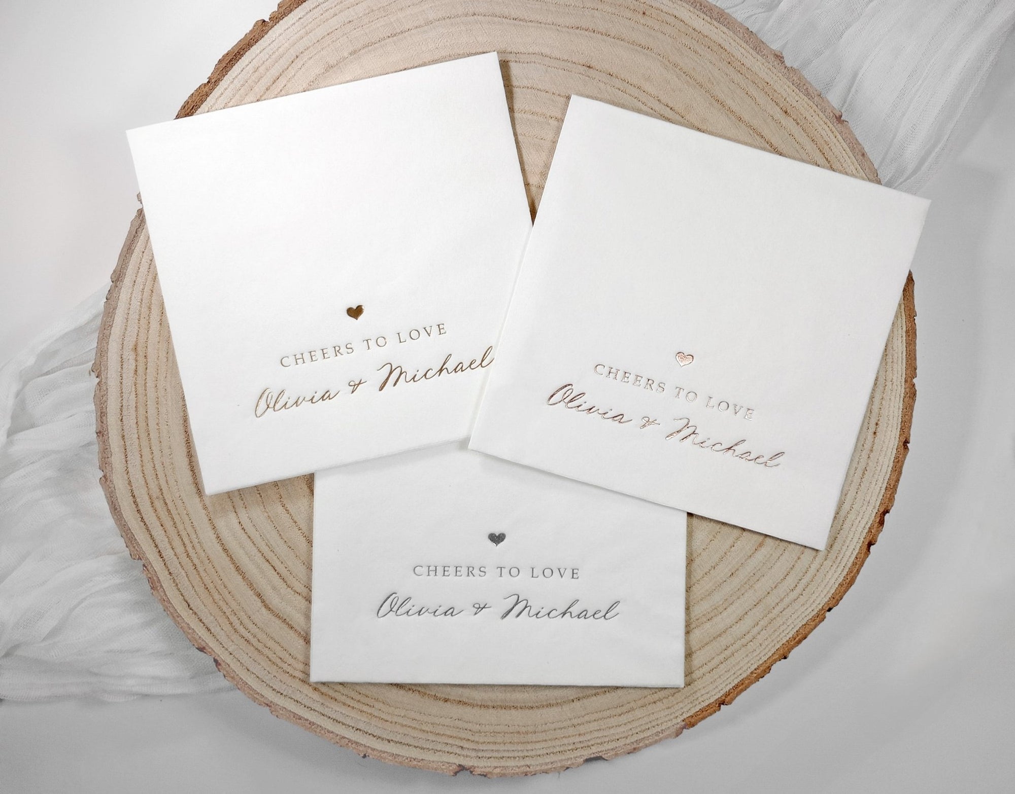 Stack of modern foil-stamped napkins in white with elegant handwritten gold lettering