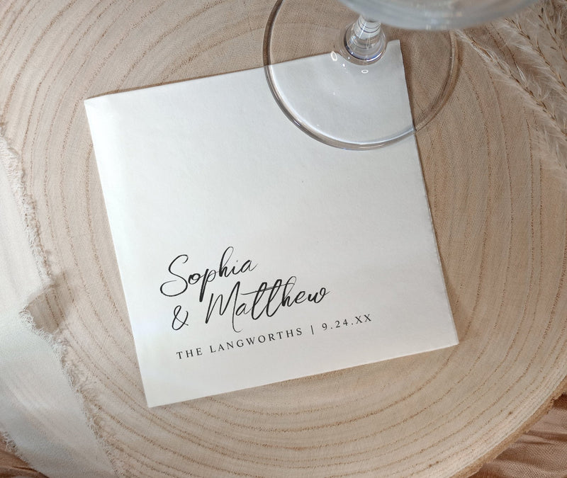 Black and white wedding napkins with handwritten names and date in modern minimalist style.
