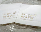 Close-up of gold foil “So We Met at a Bar” napkin placed on a reception table setting