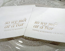 Close-up of gold foil “So We Met at a Bar” napkin placed on a reception table setting