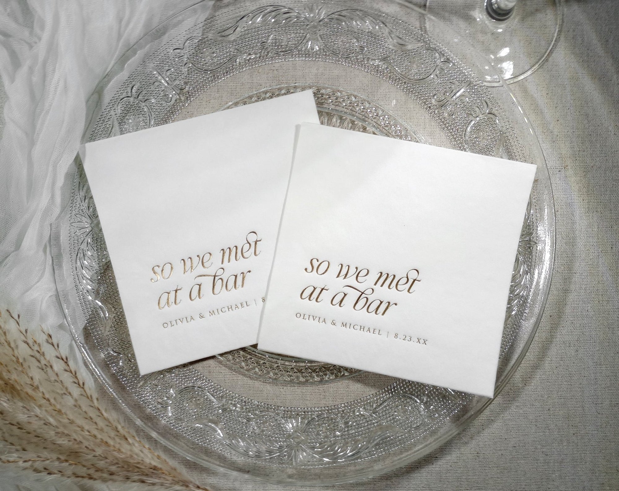 Custom foil wedding napkins fanned out to show metallic foil options and personalized text layout