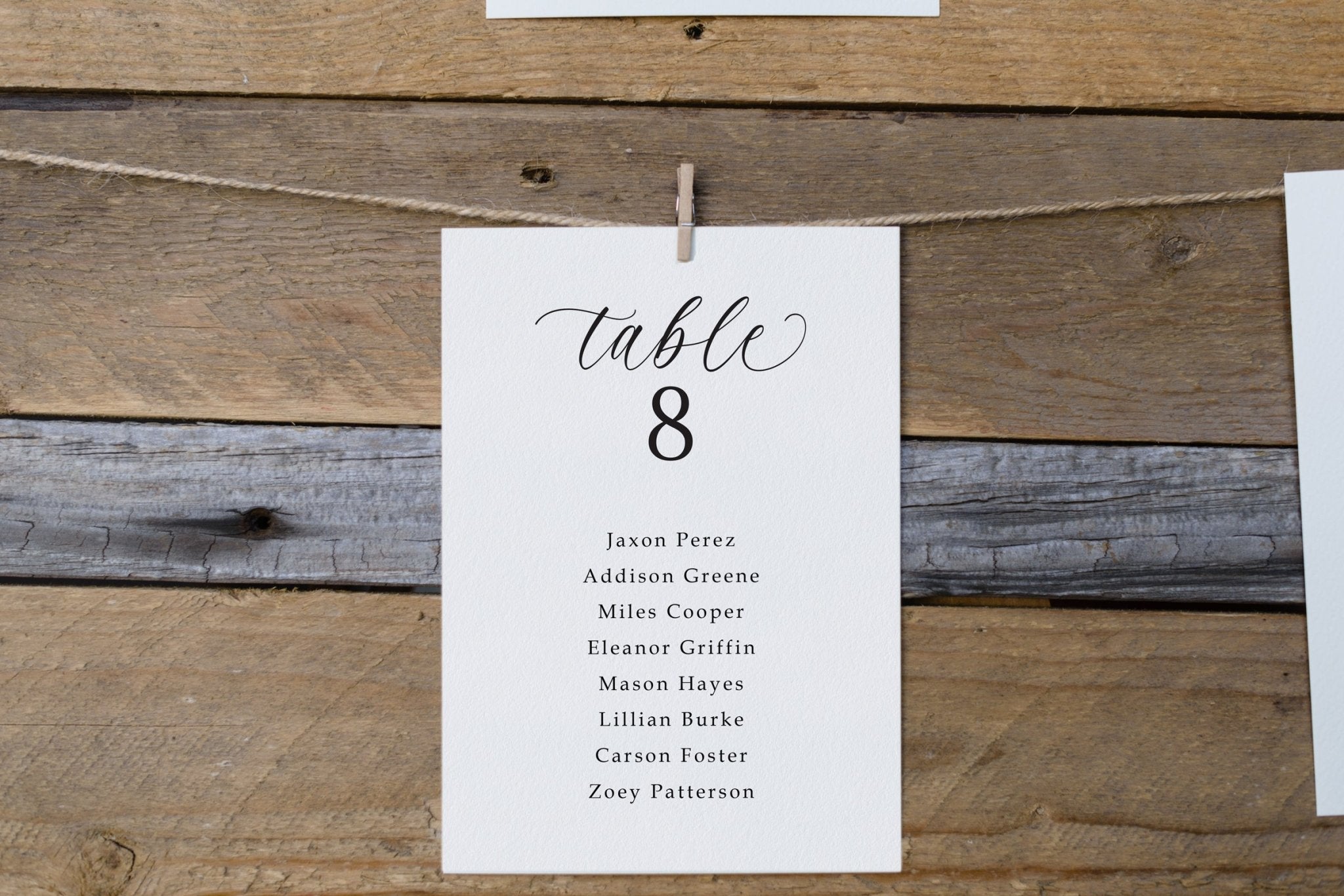 Seating chart card with names on a rustic wooden background
