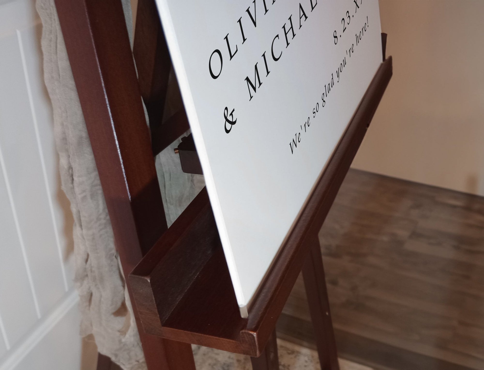 Close-up of personalized wedding welcome sign with names and date in script font